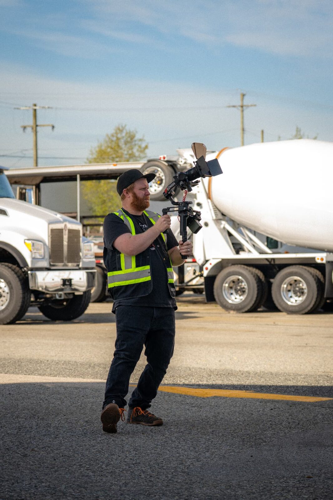 Jack operating a gimbal camera rig on location in high-vis
