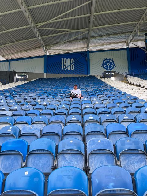 Jack sitting alone among rows of blue stadium seats